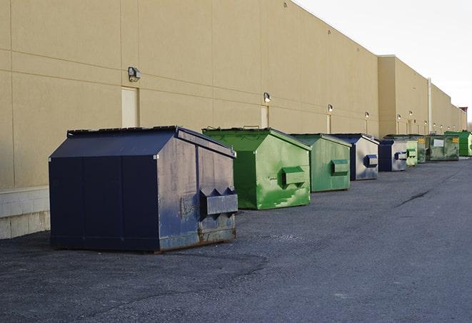 a series of colorful, utilitarian dumpsters deployed in a construction site in Holliday, TX